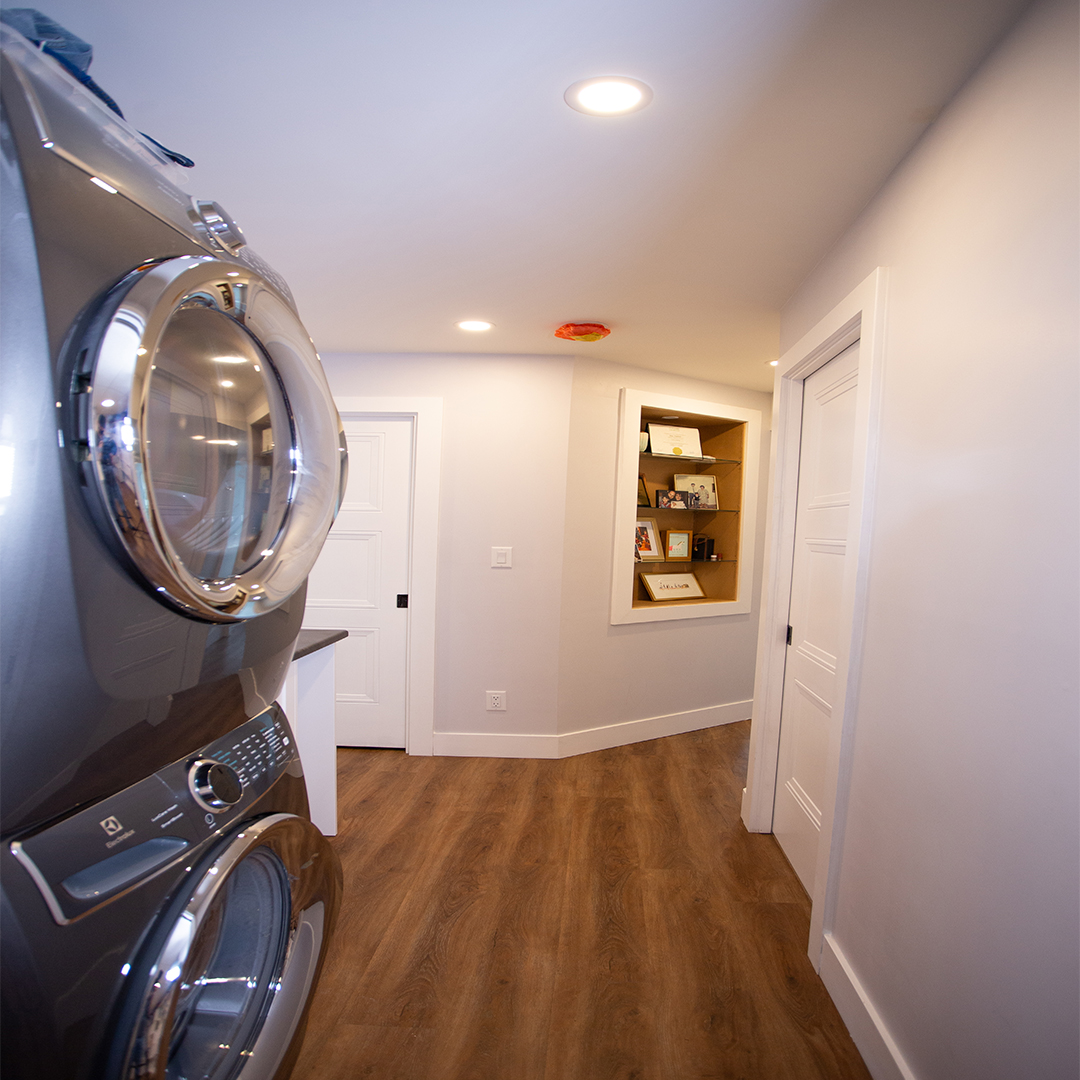 Stacking washer and dryer in modern basement hall