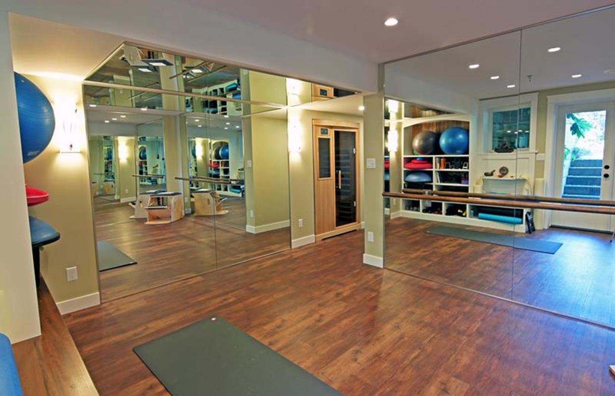 Home gym with exercise equipment and mirrored walls
