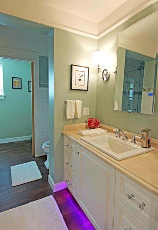 Home bathroom with purple lighting beneath cabinets