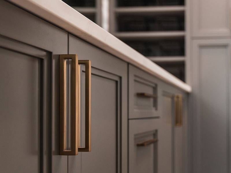 Detail of modern dark grey cabinets with gold hardware