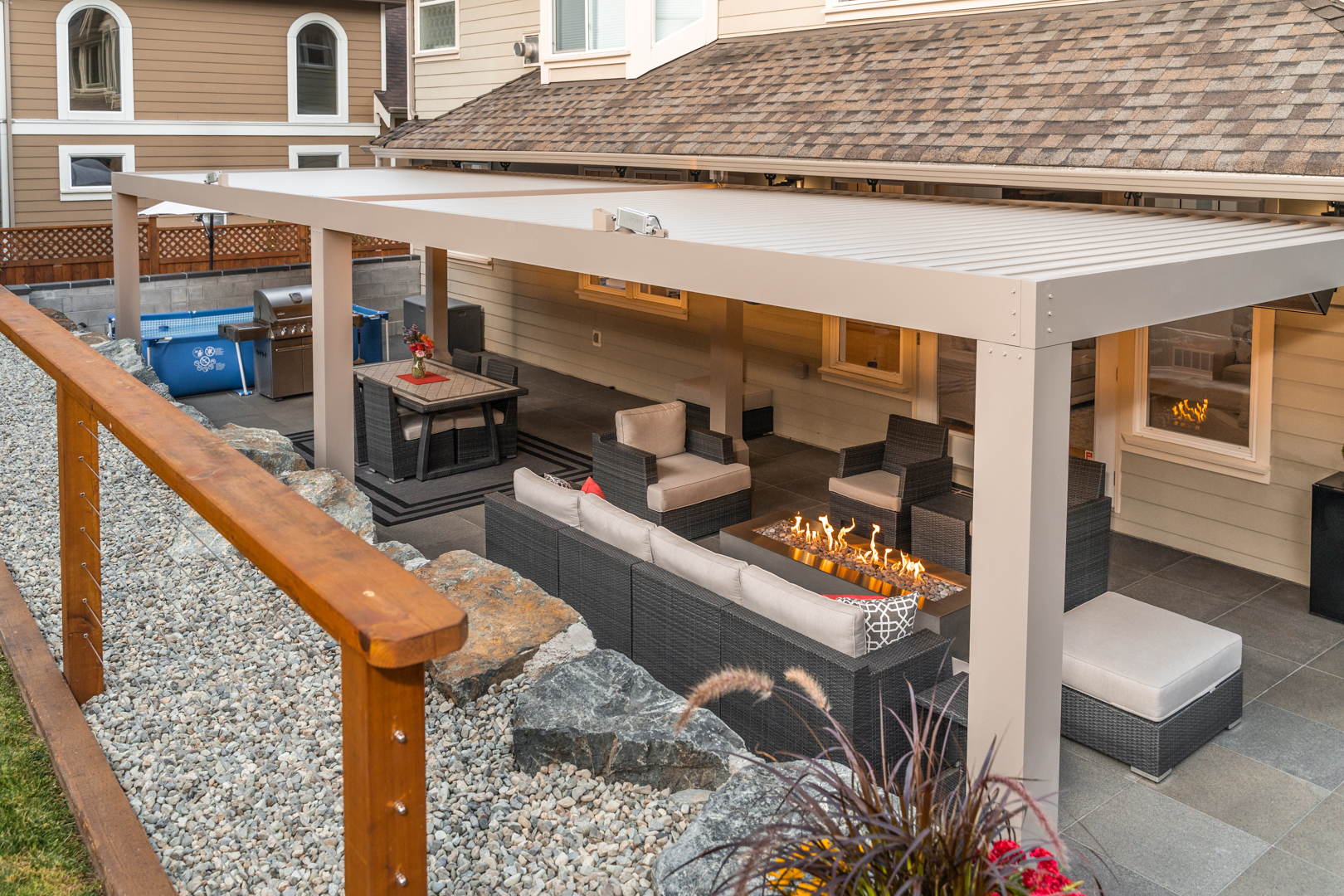 Outdoor patio under overhang of house with seating area and modern fire pit