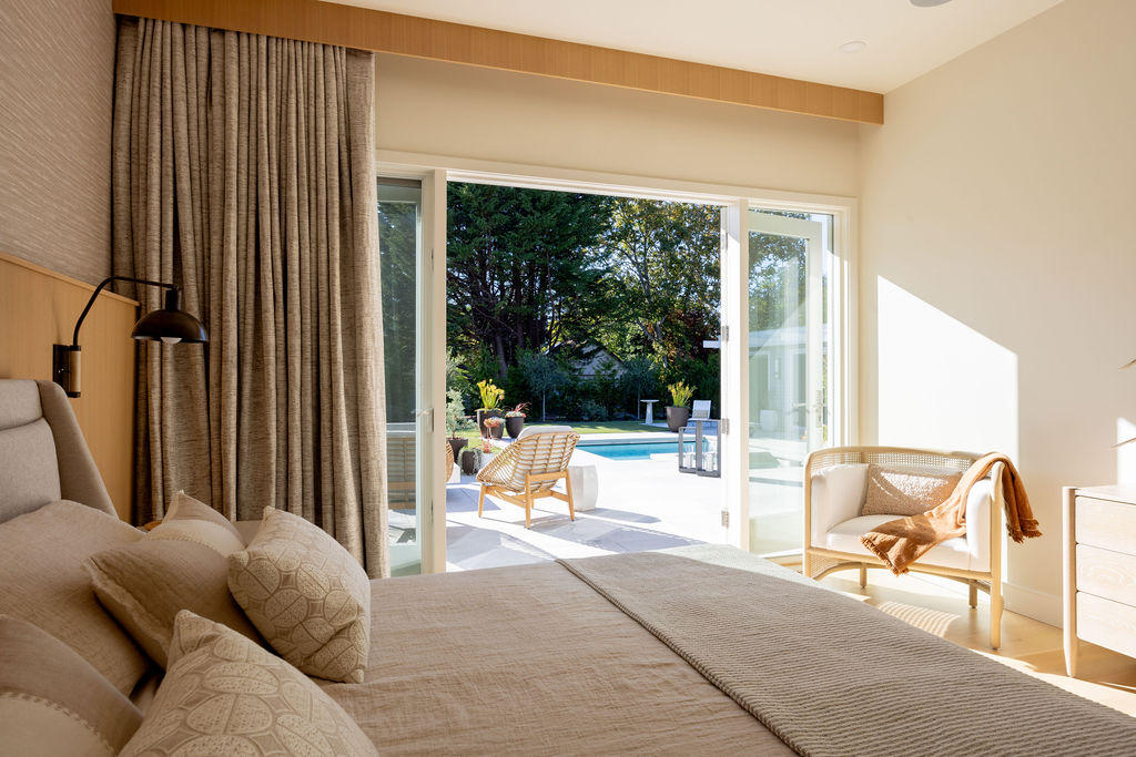 Modern bedroom with glass doors out to pool area