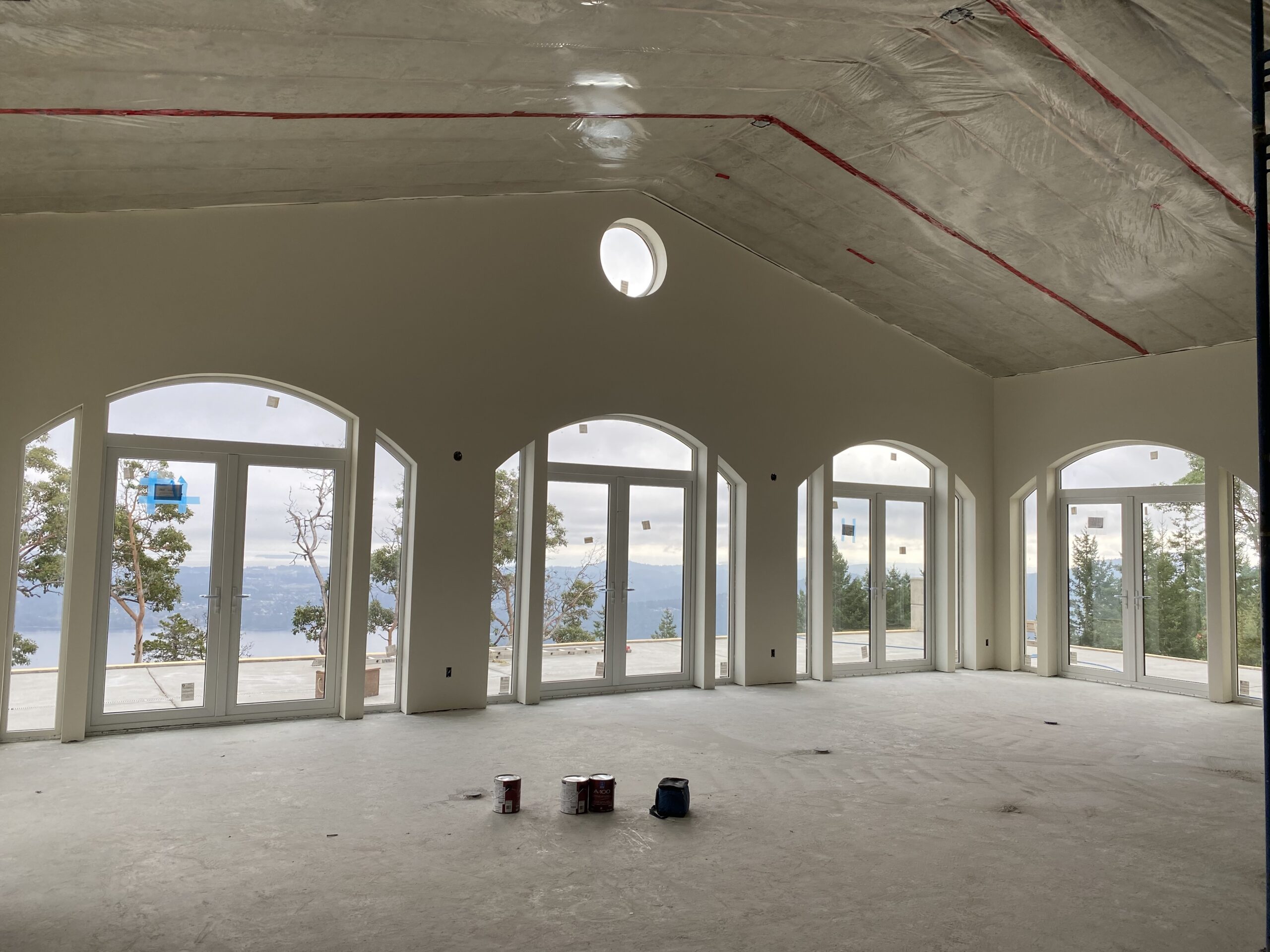 Chalet-style home with arched windows under construction