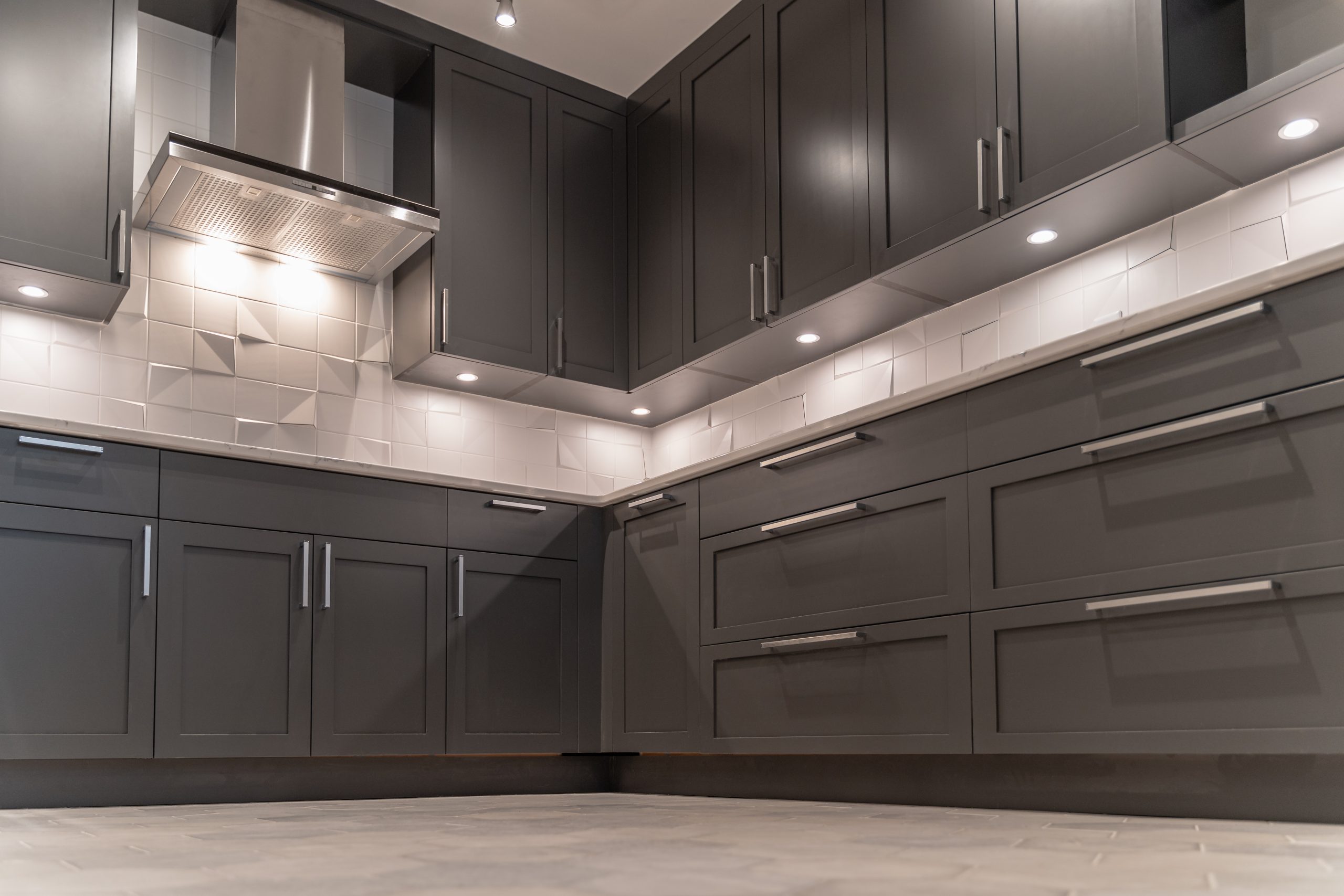 Modern kitchen with dark cabinets and unique backsplash featuring projecting tile corners