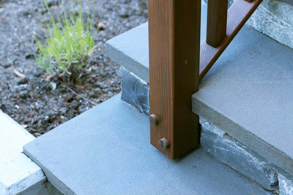 Detail of wood banister meeting stone steps