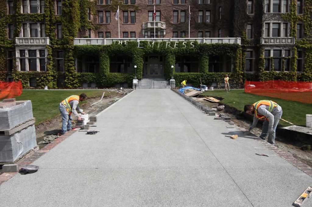 Workers building concrete walkway in front of Fairmont Empress Hotel in Victoria