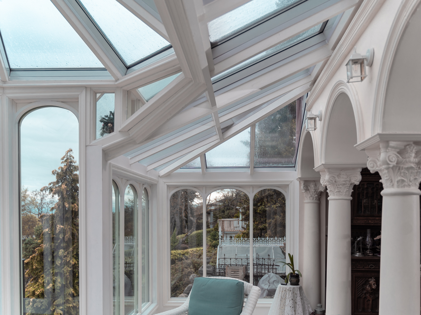 Sunroom with arched columns and windows with a view of the water