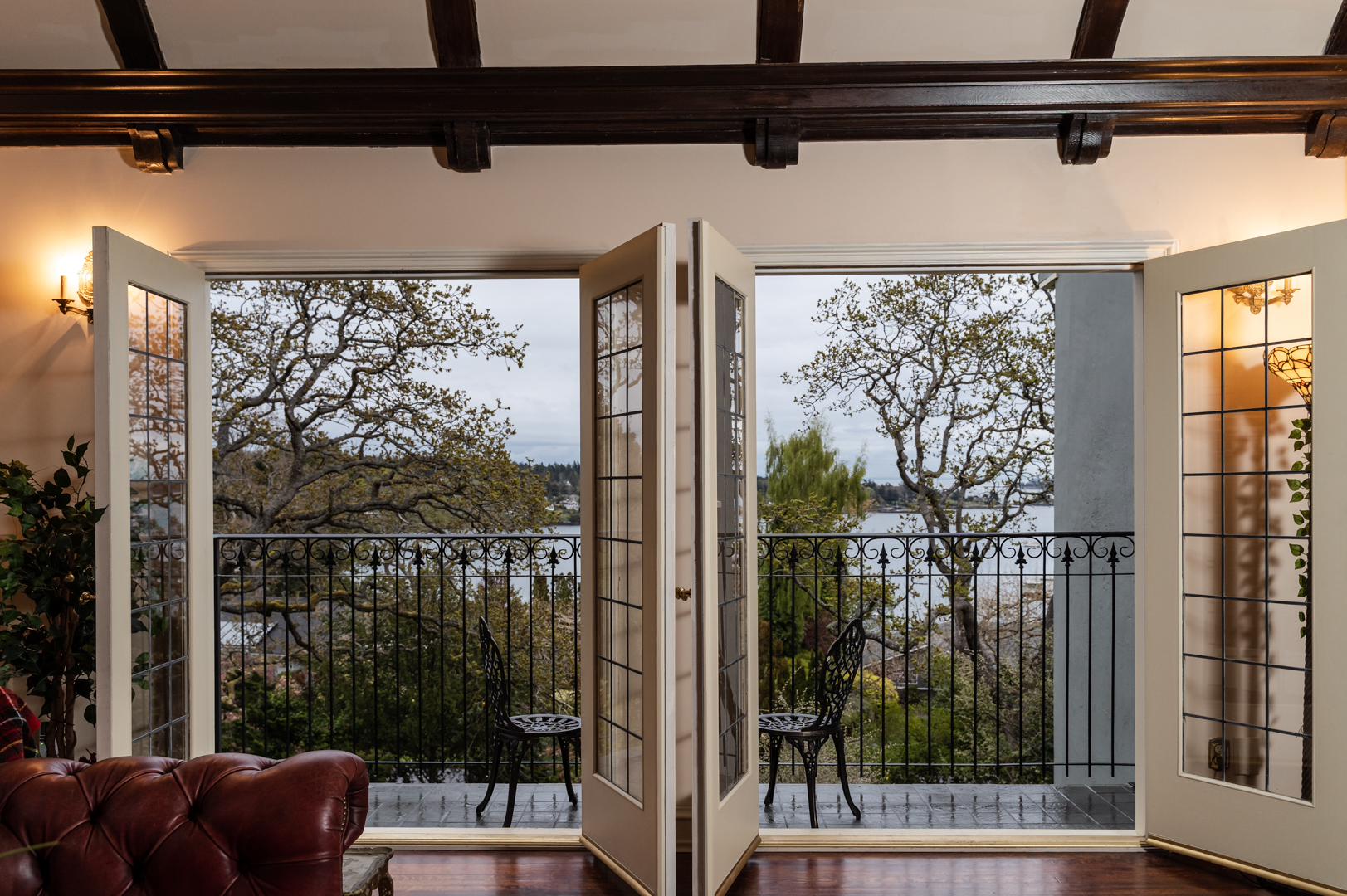 Two sets of double glass paned doors open onto balcony with wrought iron railing