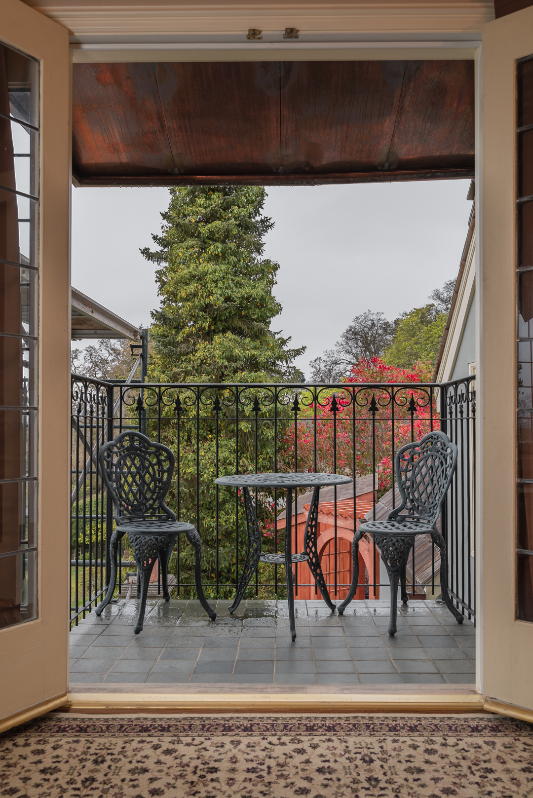 Balcony with wrought iron table, chairs, and railing