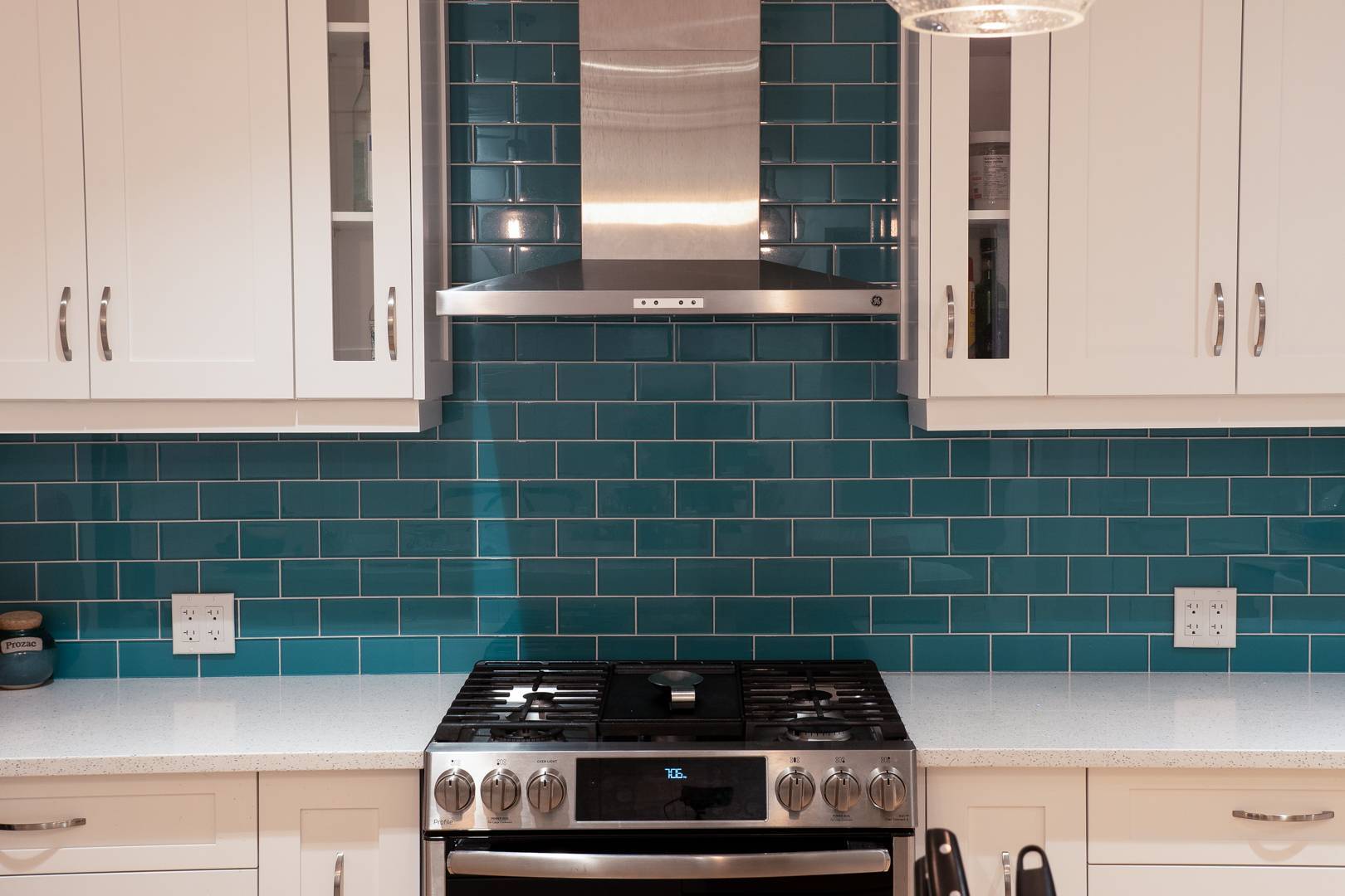 Modern kitchen with gas range and teal blue tile backsplash