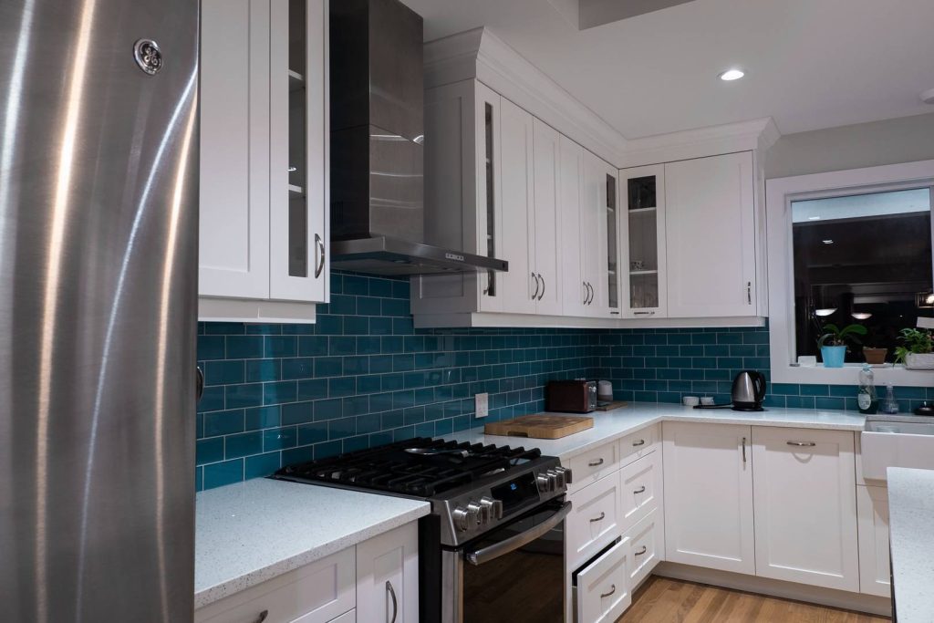 Modern kitchen with gas range and teal blue tile backsplash
