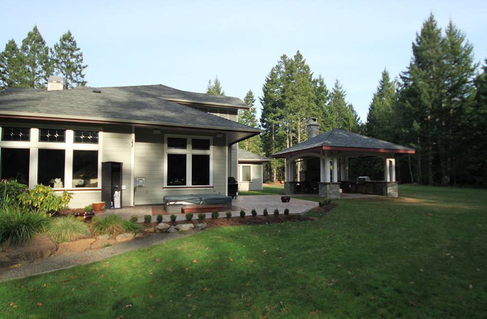 Side and back of house with patio, hot tub, and separate covered kitchen area